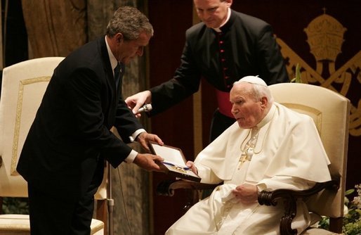 US President George W. Bush presents the Medal of Freedom to Pope John Paul II, in June 2004